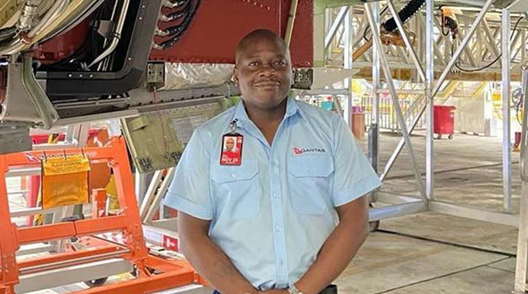 Qantas engineer in the hangar, smiling at camera